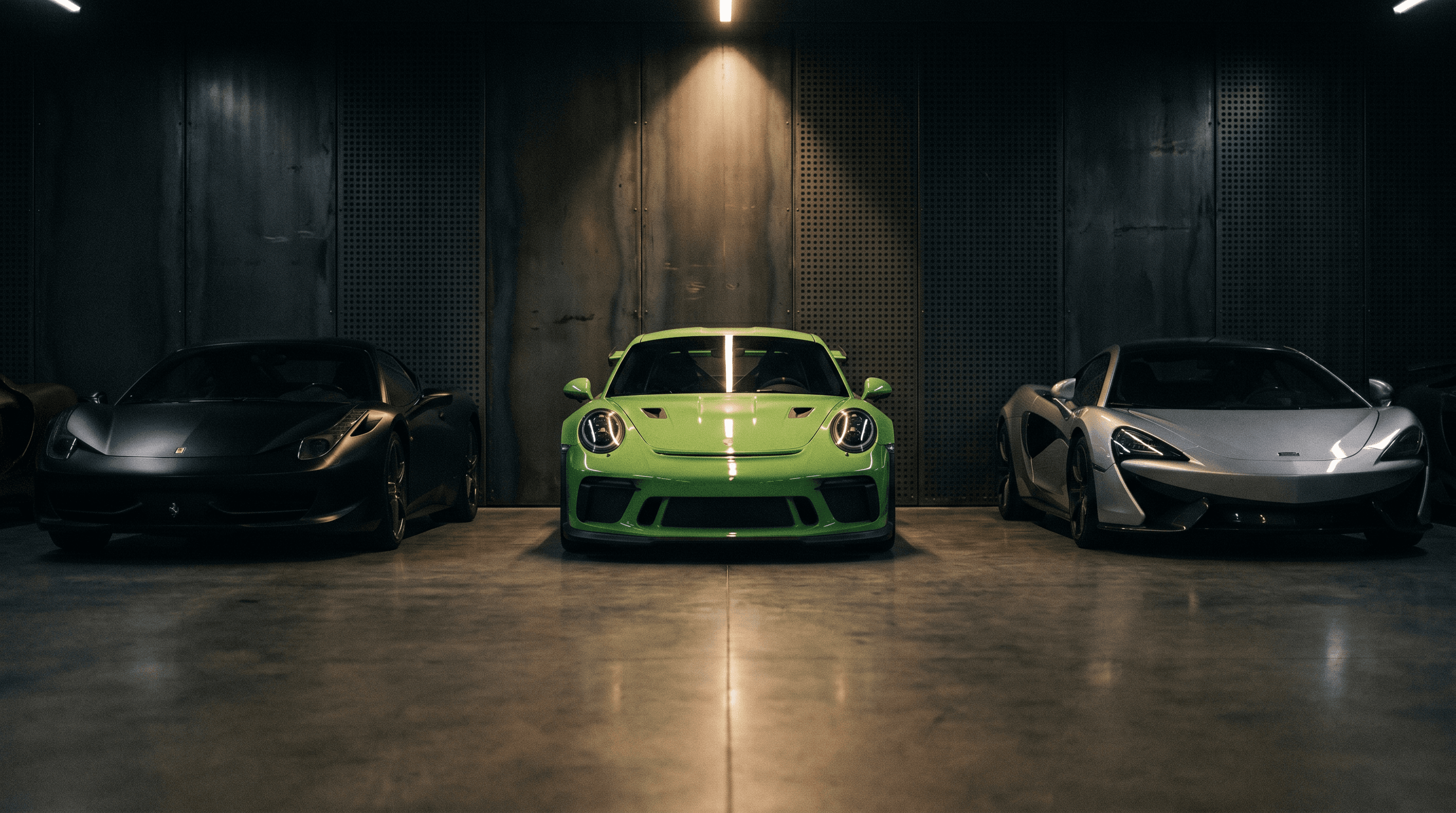 Cheval Noir Motorsports atelier interior — collection of exotic supercars in dramatic lighting